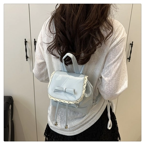 Vue détaillée du mini sac à dos bleu clair avec décoration en nœud et bordure en dentelle