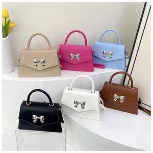 Detailed view of square handbags in six colors with silver metal bow decorations