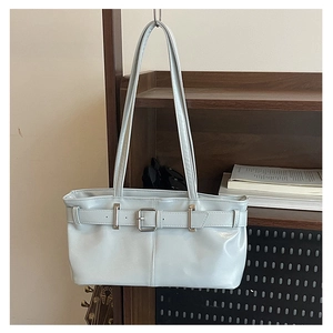 Detail of light blue PU leather handbag featuring adjustable buckle straps and dual handles
