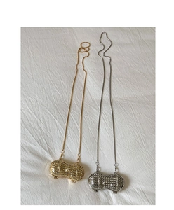 Dettaglio di mini borse a forma di arachide color oro e argento con strass lucidi
