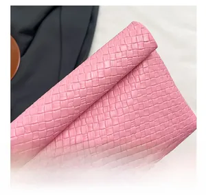 Macro detail of pink woven faux leather texture showing the classic intertwined craftsmanship