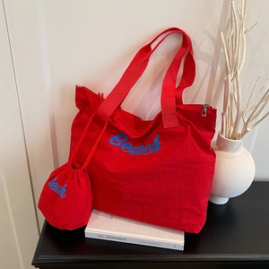 Red canvas tote bag with blue Beach embroidery and matching drawstring pouch set