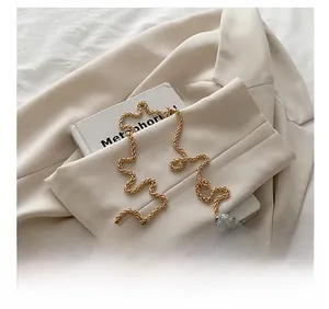 Detailed close-up of large silver sequins and a premium gold woven metal chain strap