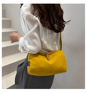 Detailed view of ginger nylon crossbody bag with drawstring closure and brand label