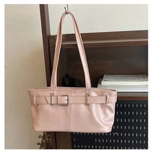 Detail of the pink shoulder bag featuring a metallic buckle and premium leather texture