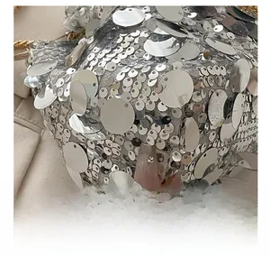 Close-up of shimmering silver sequins on the trendy bucket bag with metallic texture