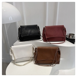 Détail de sacs à bandoulière tressés en quatre couleurs avec élégantes chaînes dorées