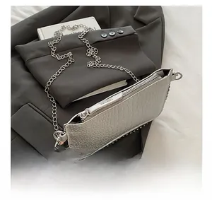 Détail du sac argenté à motif pierre montrant la fermeture éclair et les rivets fins