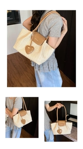 Detail of cream woven tote bag with brown leather straps and heart charm pendant