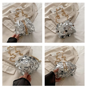 Detail view of silver sequin bucket bag with gold chain and elegant pearl drawstring accents