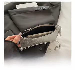 Vue détaillée du petit sac argenté à chaîne montrant la capacité pour un téléphone mobile