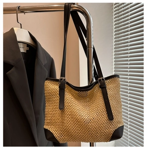 Detailed straw tote bag texture with premium leather corners and adjustable shoulder strap