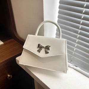 Elegante borsa bianca con fiocco in metallo argentato e manico con angolazione di 45 gradi