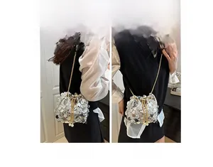 Detail of silver sequin bucket bag featuring golden chain strap and crossbody style