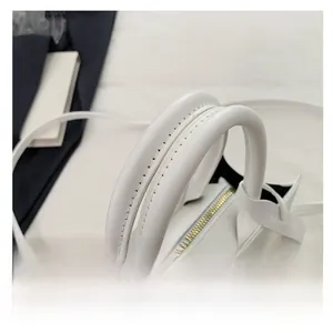 Detail of white leather handbag featuring reinforced thick dual rolled handles and gold hardware
