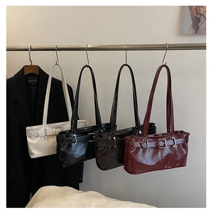 Detail view of four vintage glossy leather shoulder bags in white, black, brown and burgundy