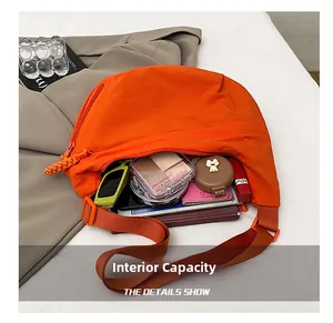Détail du grand sac besace orange montrant sa grande capacité interne et ses rangements