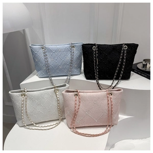 Détail de sacs cabas à chaîne matelassés avec texture brodée d'étoiles en couleurs