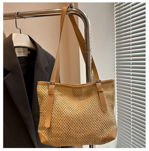 Detail of woven straw tote bag with adjustable khaki faux leather strap and reinforced base