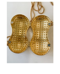 Dettaglio borsa da sera a forma di arachide con chiusura magnetica e trama interna