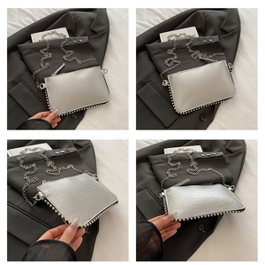 Sac rectangulaire argenté avec texture crocodile et détails de clous métalliques