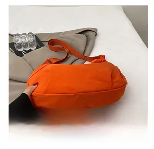 Détail du fond résistant à l'usure et texture nylon du sac besace orange vif