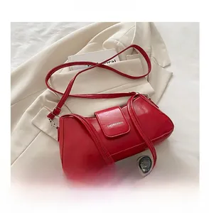 Detail of red glossy leather baguette bag with magnetic closure and size comparison to phone
