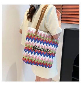 Close-up of a woven beach tote bag with wave stripes and Summer embroidery detail