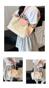 Detail of hand-woven tote bag featuring pink leather handles and heart-shaped charm