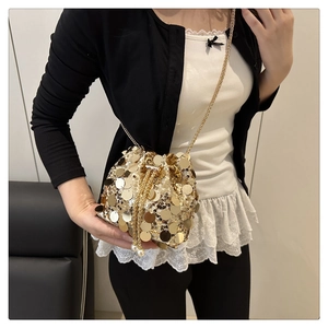 Close-up of golden sequin bucket bag featuring a drawstring closure with pearl accents