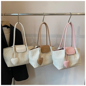 Hanging woven tote bags in three colors featuring heart-shaped leather charms and fine textures