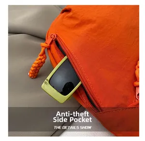 Détail du sac bandoulière orange avec poche latérale zippée antivol et corde tressée