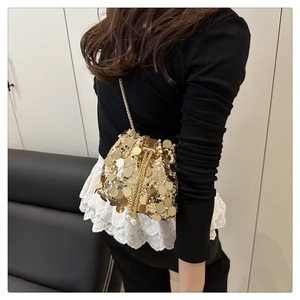 Dettaglio borsa a secchiello con paillettes dorate, coulisse di perle e tracolla a catena