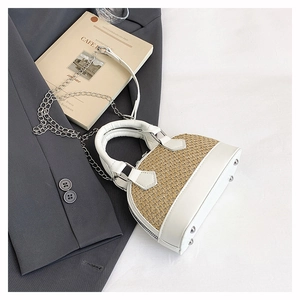 Detail of woven straw and white leather shell bag with metallic feet and chain strap