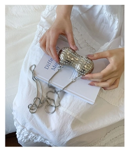 Close-up of sparkling silver peanut-shaped evening clutch with crystal rhinestones