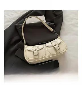 Detail view of cream vintage underarm bag with double front buckle pockets on a blazer
