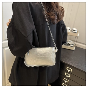 Silver crocodile textured shoulder bag with metallic bead trim and chain strap shown on model