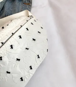 Detailed view of lightweight textured fabric with elegant small black bow prints