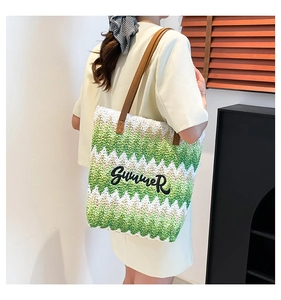 Detail of green and white woven tote bag with Summer embroidery and brown leather strap