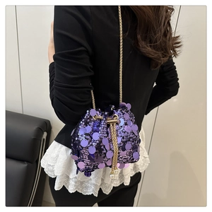 Detail of purple sequin bucket bag with gold chain and pearl drawstring charms