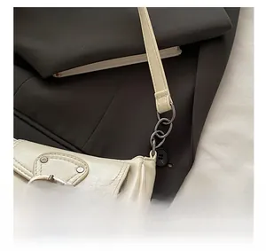 Close-up of vintage metallic hardware and beige leather texture on the bag flap