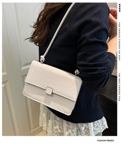 White crocodile texture shoulder bag styled on a model with a minimalist crossbody look