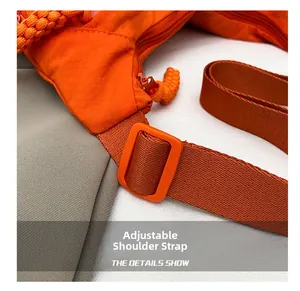 Détail du sac en nylon orange montrant la boucle réglable et la texture de la sangle
