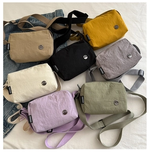 Detailed view of lightweight nylon crossbody bags in seven various minimalist colors