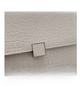 Detailed macro view of white crocodile pattern faux leather and square metal buckle