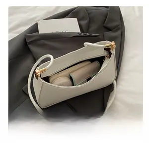 Interior view showing the storage capacity of a white leather baguette bag with essentials