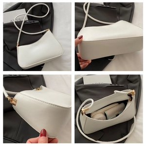 Detail view of white leather shoulder bag showing interior capacity and golden hardware