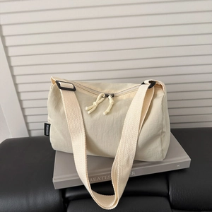 Minimalist beige nylon tote bag with top zipper and wide shoulder strap for casual daily use