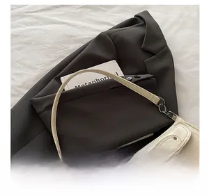 Detail of cream white leather shoulder bag featuring vintage buckle and soft strap