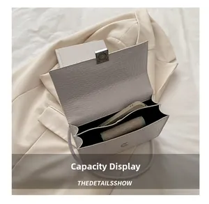 Internal view of ivory crocodile-patterned handbag showing dual storage compartments